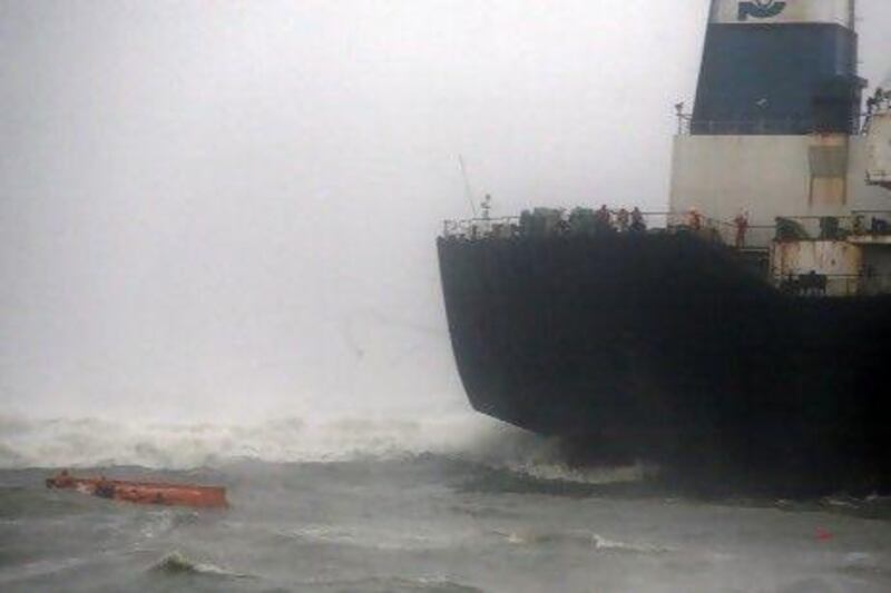 Sailors try to cling to their up-turned lifeboat, left, after it capsized while they were escaping from the Indian ship Pratibha Cauvery, which ran aground on the Bay of Bengal coastline off Chennai yesterday.