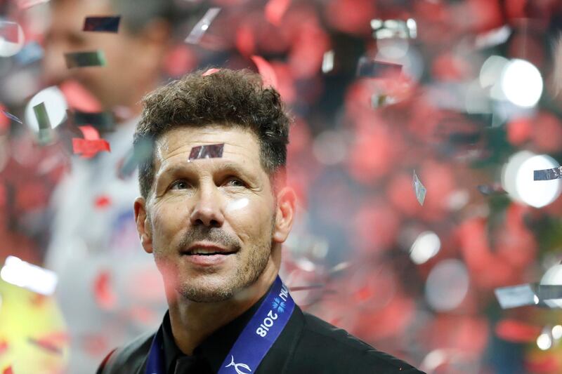 Atletico's head coach Diego Simeone is seen through flying confetti. AP
