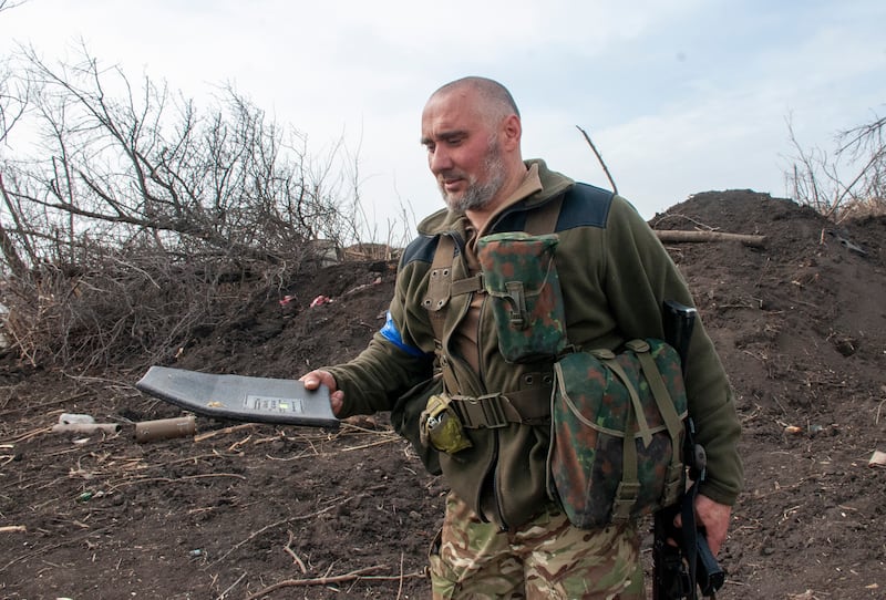 A Ukrainian soldier shows documents found as his unit inspected Russian positions that were recaptured by the Ukrainian army near the village of Mala Rohan, northeast Ukraine. EPA