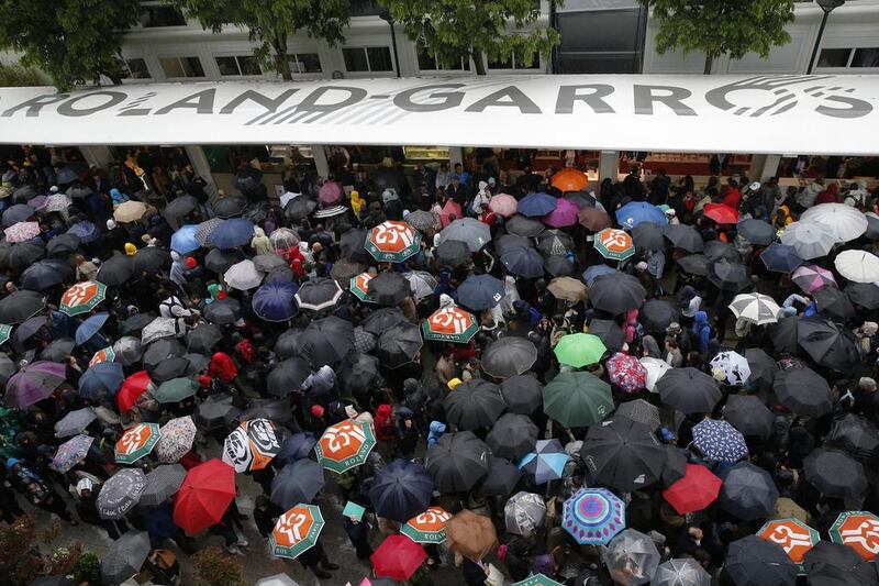 Spectators with umbrellas leave the courts as rain interrupted first round matches of the French Open tennis tournament at Roland Garros stadium in Paris, France, Sunday, May 22, 2016. (AP Photo/Christophe Ena)