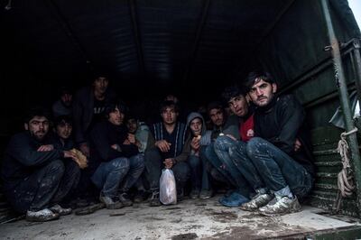 TOPSHOT - Afghan refugees collected by Turkish border army sit in the truck after being deported by Greek army officers on December 9, 2018, near Greece border in Edirne. (Photo by BULENT KILIC / AFP)