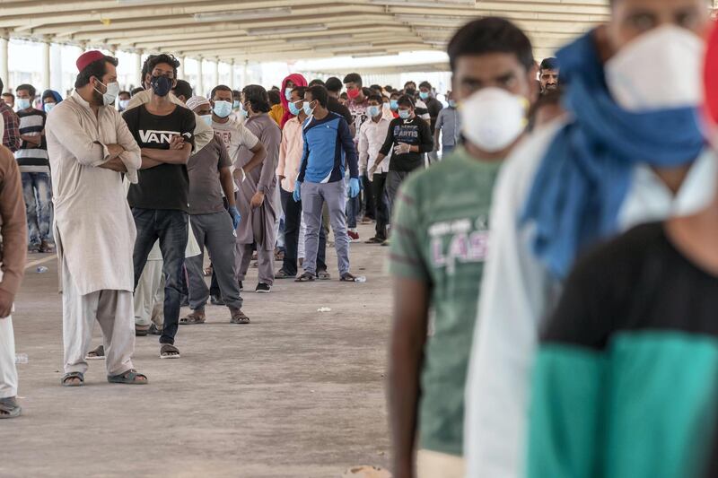 ABU DHABI, UNITED ARAB EMIRATES. 16 APRIL 2020. COVID-19 Testing station in Al Mussafah. Men wait in line for their pre-check ahead of being tested. (Photo: Antonie Robertson/The National) Journalist: Haneen Dajani. Section: National.