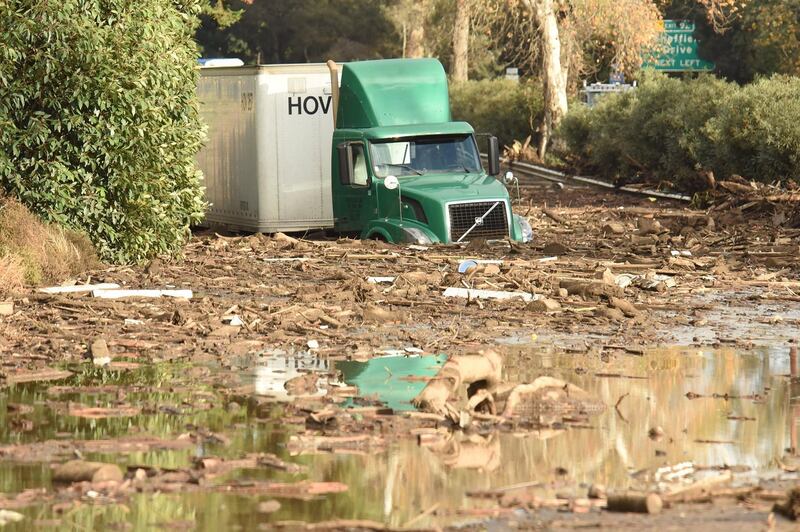 Aa semi-tractor trailer sitting stuck in mud on US Highway 101 northbound just south of the San Ysidro Road off-ramp following heavy rains in Montecito, California. Mike Eliason / Santa Barbara County Fire / EPA
