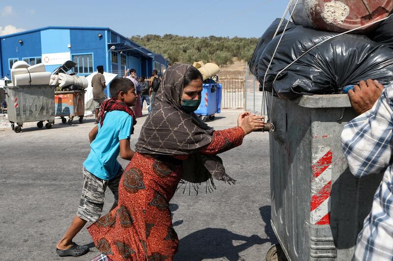 Refugees and migrants who were sheltered near the destroyed Moria camp, carry their belongings as they prepare to move to a new temporary camp, on the island of Lesbos, Greece.  Reuters