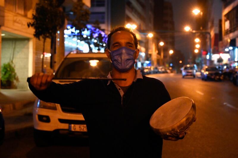 A Lebanese drummer wears a protective mask and carries a small drum as he makes his rounds waking Muslims for Suhor, the meal taken during Ramadan before sunrise prayers, amid a lockdown due to the ongoing coronavirus Covid-19 pandemic in Beirut.  EPA