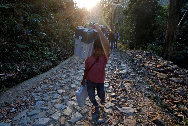 A porter carries a Voter Verifiable Paper Audit Trail machine and an Electronic Voting Machine through Buxa tiger reserve forest to a remote polling station, in Alipurduar district in the eastern state of West Bengal. Reuters