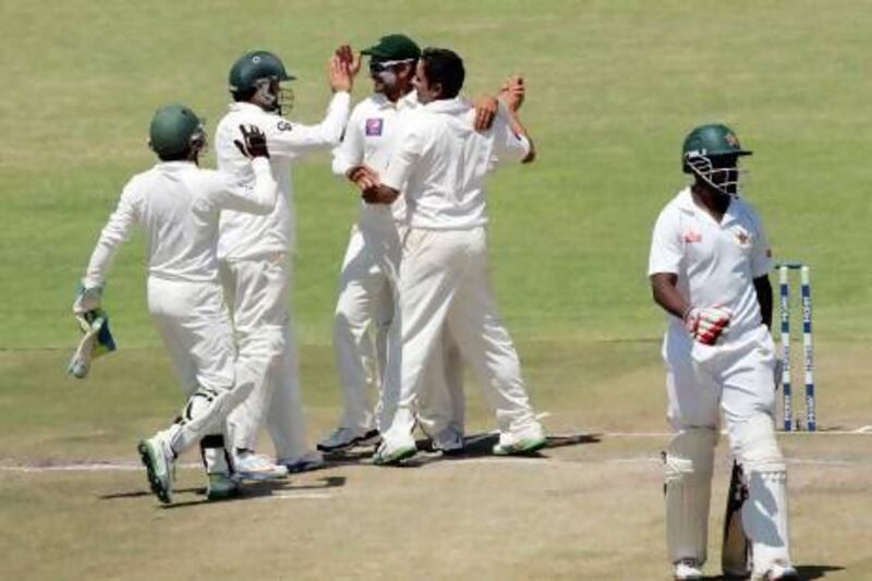 Saeed Ajmal, centre, took 11 wickets in the match, his fourth 10-plus wicket haul in Tests for Pakistan as Zimbabwe collapsed at Harare. Jekesai Njikizana / AFP