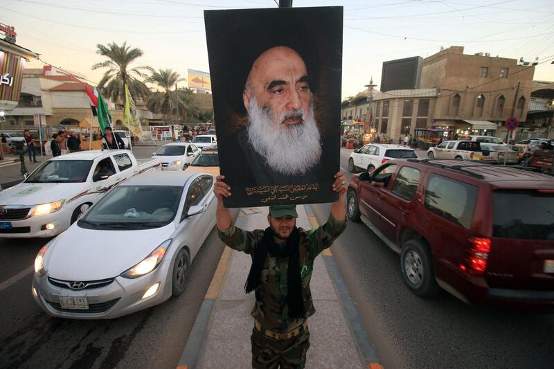 A member of the Hashed al-Shaabi (Popular Moblisation units) carries a portrait of Iraqi Shiite cleric Grand Ayatollah Ali al-Sistani in a street in the southern city of Basra on December 10, 2017, amidst victory celebrations after Baghdad declared in the war against the Islamic State (IS) group.
Baghdad declared victory in its war to expel the jihadists, three years after the group proclaimed a cross-border "caliphate" stretching into Syria, endangering Iraq's very existence. / AFP PHOTO / HAIDAR MOHAMMED ALI