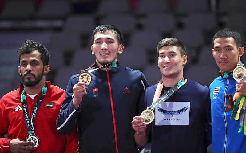 Medalists from left to right, Talib Alkirbi of United Arab Emirates, with silver, Torokan Bagynbai Uulu of Kyrgyzstan, with gold, Nartay Kazhekov of Kazakhstan and Banpot Lertthaisong of Thailand, with bronze during the victory ceremony of men's -69 kilogram jujitsu at the 18th Asian Games in Jakarta, Indonesia, Friday, Aug. 24, 2018. (AP Photo/Firdia Lisnawati)