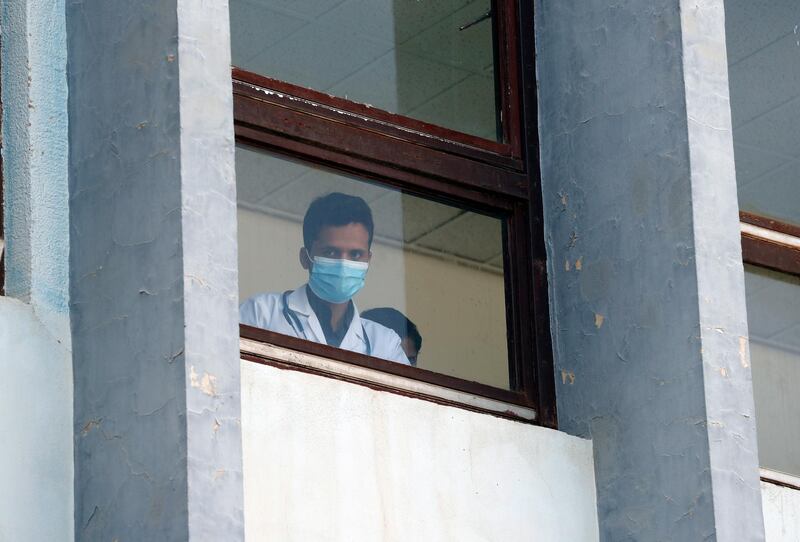 A Yemeni medic wearing a protective face mask looks out from a window of a hospital amid concerns over the coronavirus Covid-19 pandemic, in Sanaa. EPA