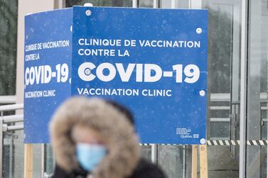 A pedestrian passes in front of a sign for a Covid-19 vaccination clinic in Montreal, Quebec, Canada, on Thursday, Jan. 21, 2021. Even though Canada has secured more vaccines per capita than any other nation, "it doesn't mean much" when the bulk is not yet being delivered, an epidemiologist at the University of Toronto said. Photographer: Christinne Muschi/Bloomberg