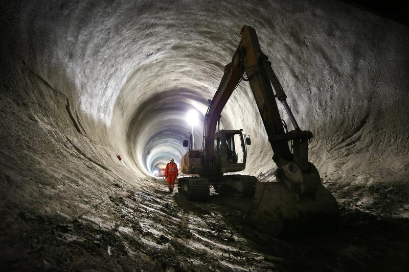 A worker walks past a digger in the partially completed Crossrail rail tunnel that will become Bond Street station. Peter Macdiarmid / Getty Images