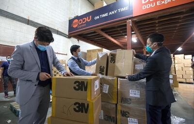 Dubai, United Arab Emirates -(L-R) Li Jiaqi, Cai Chang and Li Huafei helping with boxes of mask to be shipped to China at DDU express, Al Quoz Industrial area.  Leslie Pableo for The National for Ramola's story
