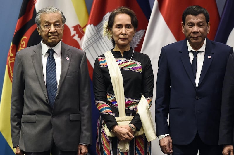 Malaysia's Prime Minister Mahathir Mohamad (L), Myanmar State Counsellor Aung San Suu Kyi and Philippine President Rodrigo Duterte pose for a group photo before the start of the ASEAN-Plus Three (APT) summit on the sidelines of the 33rd Association of Southeast Asian Nations (ASEAN) summit in Singapore on November 15, 2018. / AFP / Lillian SUWANRUMPHA
