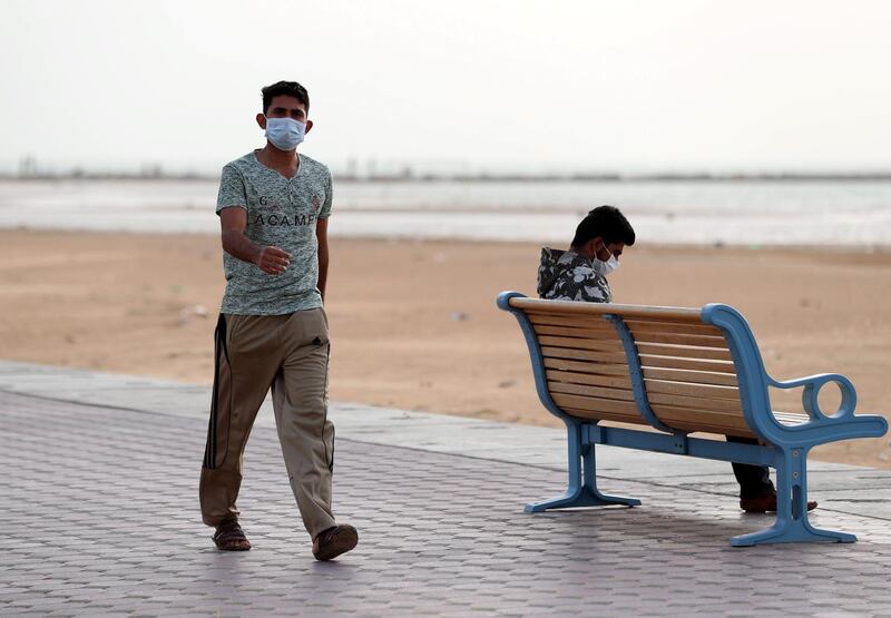 Ajman, United Arab Emirates - Reporter: N/A: Men wear a face masks in front of the beach in Ajman as a response to the Corona Virus. Monday, March 23rd, 2020. Ajman. Chris Whiteoak / The National