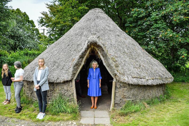 Camilla, Duchess of Cornwall, peers out from a traditional straw hut during a visit to the Youth Action Wiltshire Oxenwood Outdoor Activity Centre near Marlborough where she is meeting young carers and reopening the centre, which was shut during the coronavirus lockdown, in Marlborough, England. Getty