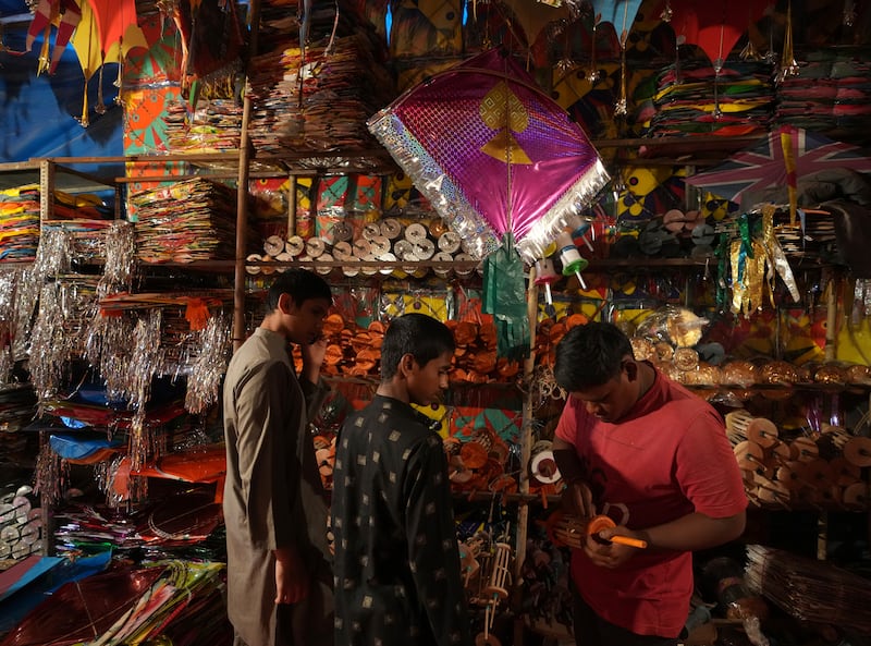People shop for kites, to take part in good-natured kite-fighting competitions as part of Makar Sankranti celebrations. AP
