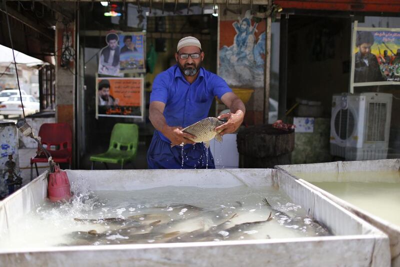 An Iraqi Shi’ite man sells traditional Iraqi Masgouf fish in Sadr City.