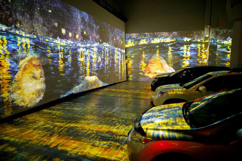 People sit in their cars as they experience a drive-in immersive Vincent Van Gogh art exhibit. AFP