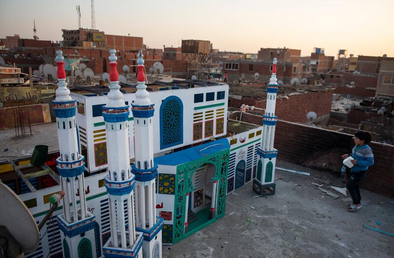 A child walks by a wooden mosque set up as Ramadan decoration to welcome the holy month in Egypt's capital city Cairo. Muslims in large parts of the world start the month of fasting on Tuesday. EPA