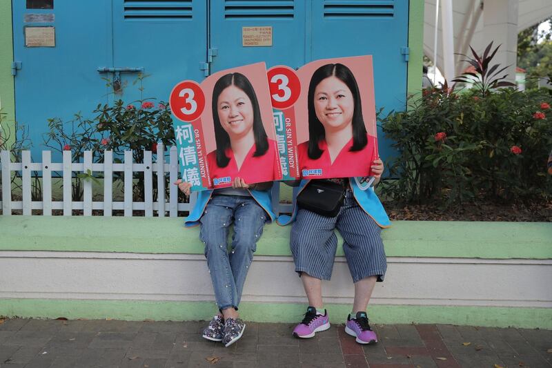 Supporters of Or Sin-yi Windy, a pro-China candidate in Hong Kong's District Council election, hold her posters. AP Photo