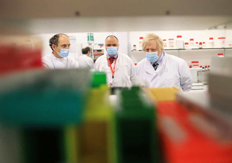 British Prime Minister Boris Johnson meets with Dr David Simpson and Professor Jose Bengoechea during a visit to the Wellcome-Wolfson Institute For Experimental Medicine at Queen's University Belfast. AFP