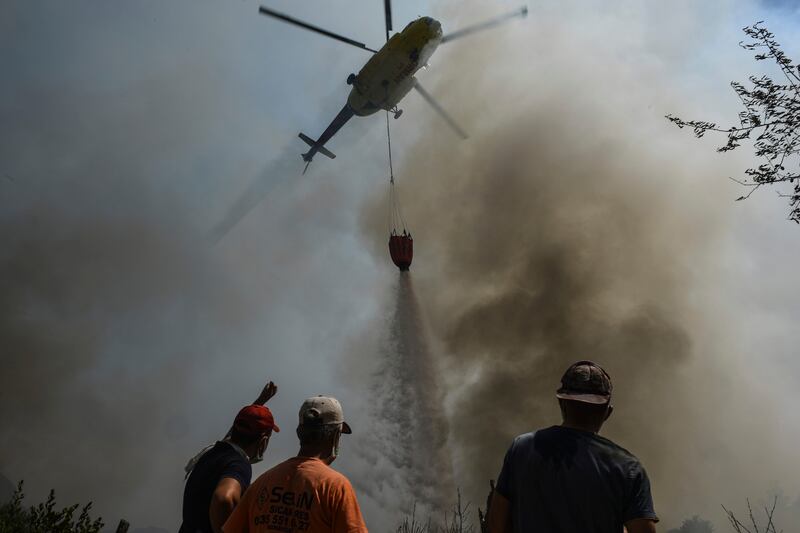 A helicopter pours water on Sirtkoy.