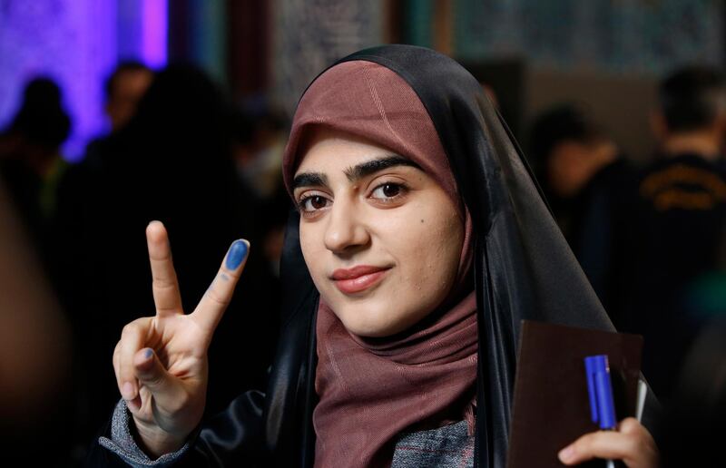 A woman gestures as she casts her vote at a polling station during the parliamentary elections in Tehran, Iran. Iranians head to polls amid a worsening economic crisis and escalating tensions with the United States.  EPA