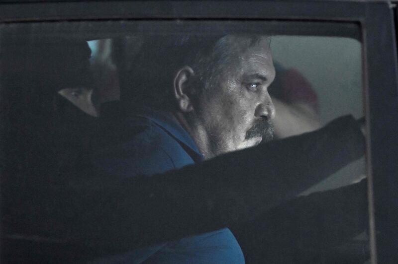 Fugitive Greek neo-Nazi deputy leader Christos Pappas is escorted in a police car after his hearing. AFP