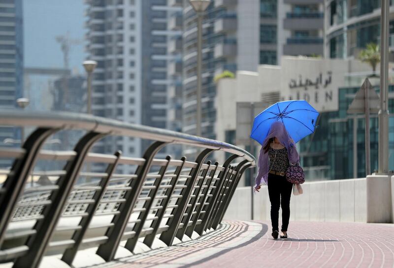 Dubai, United Arab Emirates - May 6th, 2018: Standalone. Weather. A women protects her self from the sun on a hot day in Dubai. Sunday, May 6th, 2018 at The Marina, Dubai. Chris Whiteoak / The National