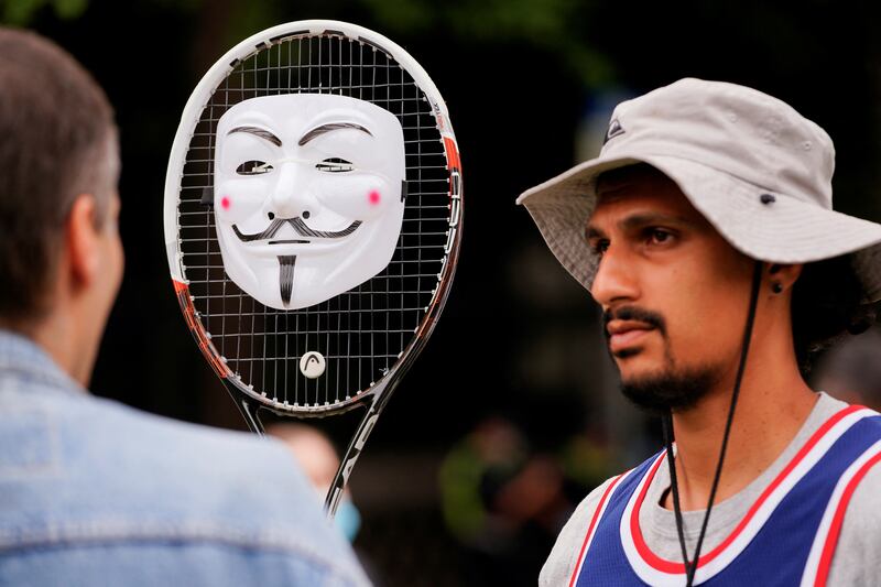 A supporter of Serbian tennis player Novak Djokovic holds a decorated tennis racket. Reuters