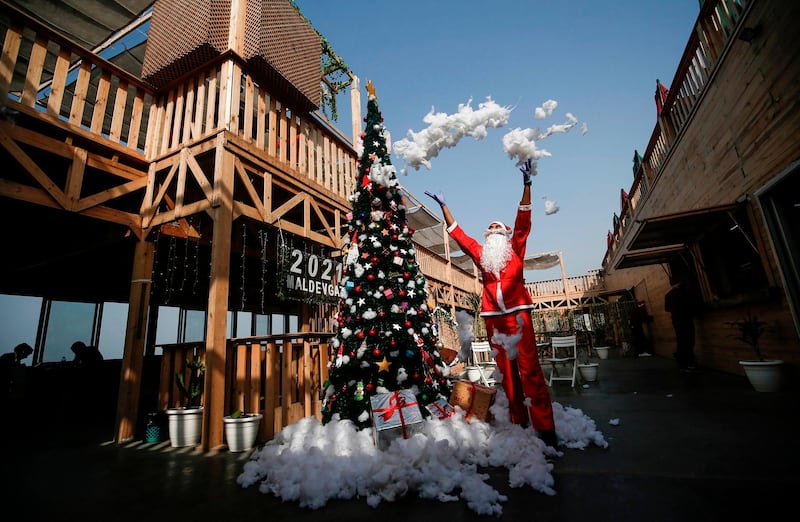 Palestinian cafeteria employees dressed as Santa Claus decorate a Christmas Tree in Gaza City. AFP