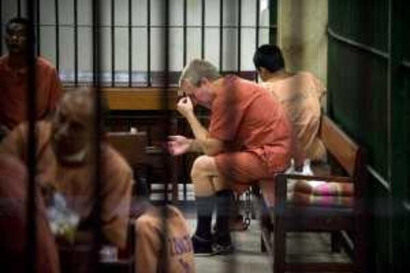 Michael Bryan Smith, 43, from Britain gestures as he sits in a cell at the Criminal Court in Bangkok on February 18, 2010.  A Thai court agreed to extradite a Smith to Dubai on charges of embezzling 150 million dollars, in a case that has possible implications for fugitive former premier Thaksin Shinawatra.  AFP PHOTO / Nicolas ASFOURI *** Local Caption ***  887468-01-08.jpg