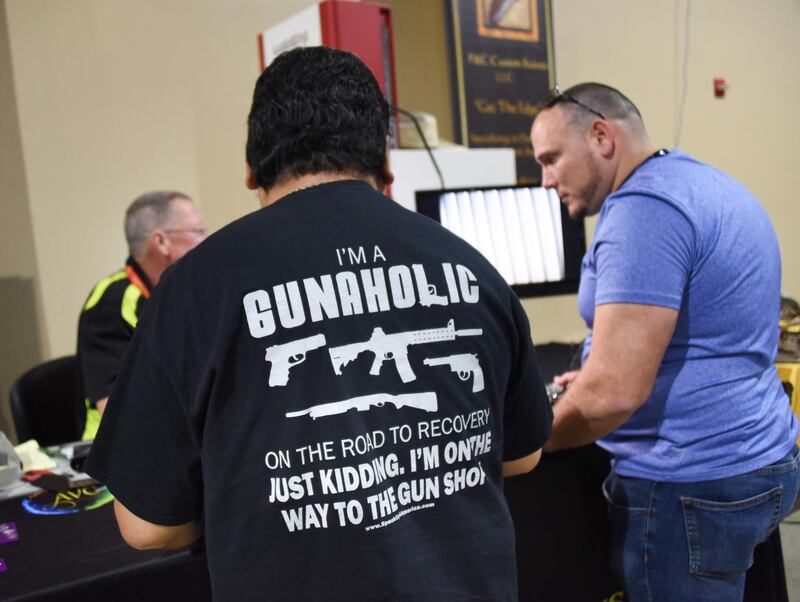 A gun enthusiast attends the South Florida Gun Show at Dade County Youth Fairgrounds in Miami, Florida, on February 17, 2018.
The gun show started three days after a mass shooting 30 miles (48kms) away at the Marjory Douglas High School in Parkland, Florida. Vendors said they were expecting a big turnout and sales, and because of the shooting there will be a panic regarding gun restrictions and new laws that could be put in place. Vendor Domingo Martin said he brought his entire stock of of 42 AR-15's, adding that he is not the only one selling the unit at the weekend show.  / AFP PHOTO / Michele Eve Sandberg
