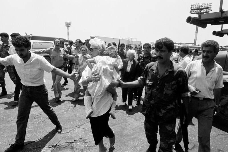 Shiite Amal militias ans Lebanese soldiers take American passengers of a TWA Boeing 727 to the Beirut airport terminal on June 14, 1985. 17 women and two children were released. Flight 847 of TWA was hijacked on June 14, 1985 by members of Hezbollah and Islamic Jihad shortly after take off from Athens.   AFP PHOTO ISMAIL (Photo by NABIL ISMAIL / AFP)