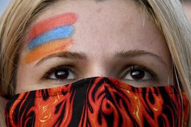 A woman listens during a demonstration held by the Armenian Youth Federation outside the Consulate General of Azerbaijan on Wednesday, Sept. 30, 2020, in Los Angeles. Heavy fighting between Armenian and Azerbaijani forces over the separatist region of Nagorno-Karabakh continued for a fourth straight day on Wednesday, with statements from both sides indicating that the flare-up of a decades-old conflict that has killed dozens of people since Sunday was no closer to an end. (Keith Birmingham/The Orange County Register via AP)