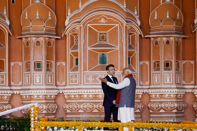 India's Prime Minister Narendra Modi (R) and France's President Emmanuel Macron talk during their visit the Hawa Mahal, also known as the Palace of the Winds, in Jaipur. AFP
