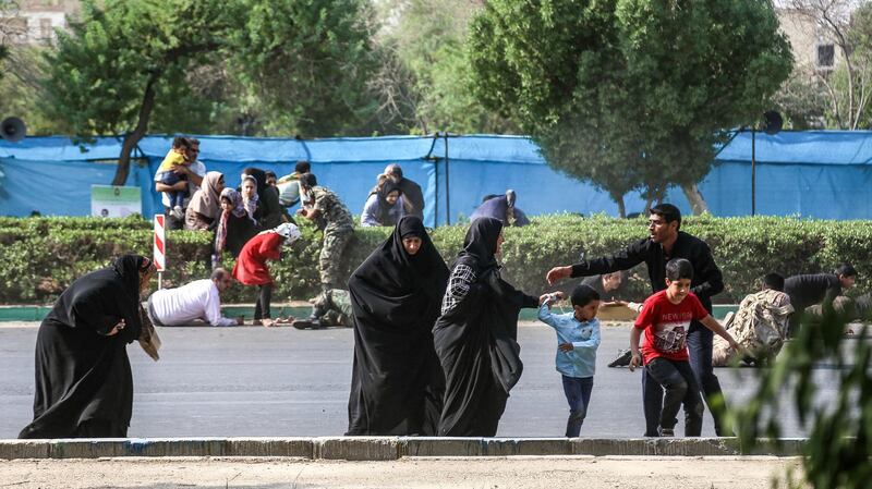 A man helps women and children as they try to flee at the scene of the attack on the military parade. AFP