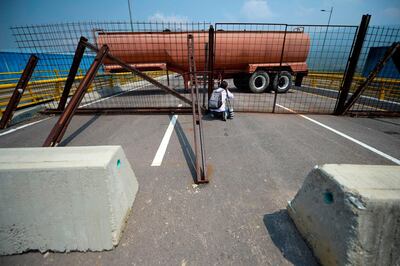 A photographer takes apicture as Venezuelan military forces block with containers the Tienditas Bridge, which links Tachira, Venezuela, and Cucuta, Colombia, on February 6, 2019.  Venezuelan military officers blocked a bridge on the border with Colombia ahead of an anticipated humanitarian aid shipment, as opposition leader Juan Guaido stepped up his challenge to President Nicolas Maduro's authority. / AFP / Raul Arboleda
