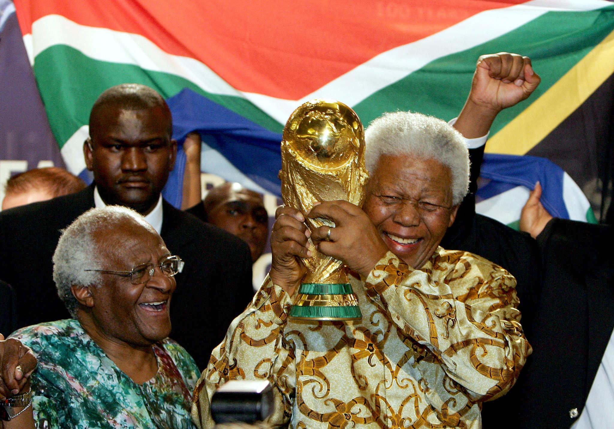 Nelson Mandela holds the Jules Rimet World Cup beside Desmond Tutu. AFP