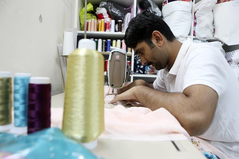 Tailors busy at work custom-making the creations at the shop. Pawan Singh / The National