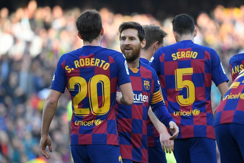 Barcelona's Spanish defender Sergi Roberto (L) celebrates with Barcelona's Argentine forward Lionel Messi  after scoring during the Spanish league football match between FC Barcelona and Getafe CF at the Camp Nou stadium in Barcelona on February 15, 2020. / AFP / LLUIS GENE
