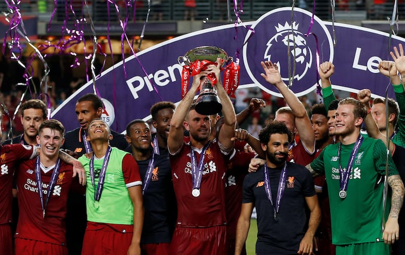 Liverpool's Jordan Henderson lifts the Premier League Asia Trophy  alongside team mates. Bobby Yip / Reuters