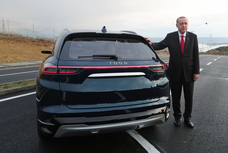 Turkish President Recep Tayyip Erdogan poses next to the prototype of the TOGG brand car, in Kocaeli, Turkey. EPA