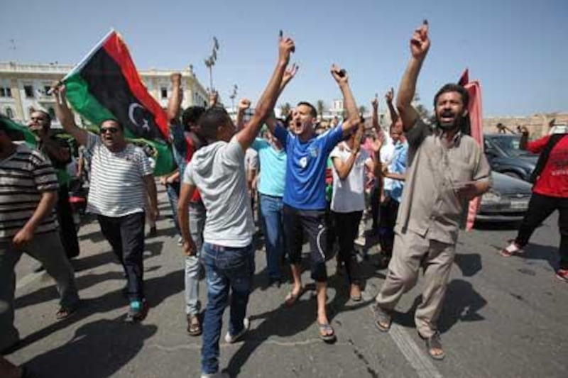 Libyans hold up their ink-marked fingers that shows they have voted as they celebrate in Martyrs' Square in Tripoli, Libya.