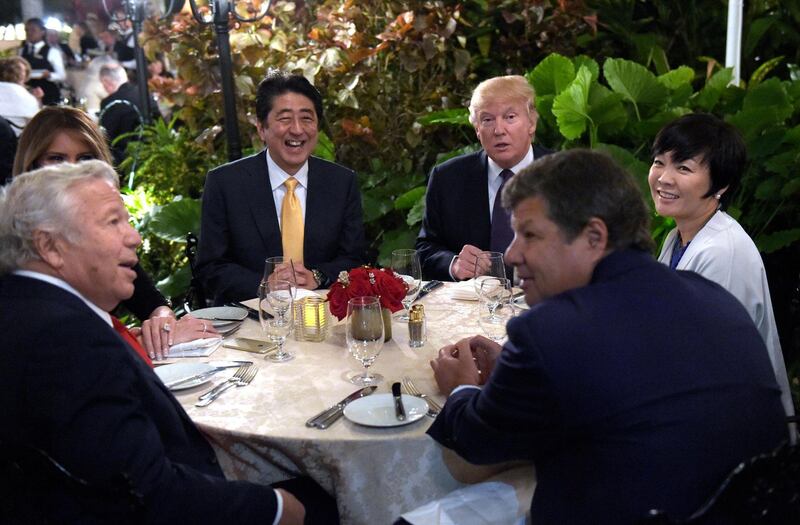 President Donald Trump, third from right, and first lady Melania Trump, hidden at left, sit down to dinner with Japanese Prime Minister Shinzo Abe, third from left, and his wife Akie Abe, right, at Mar-a-Lago in Palm Beach, Florida, US. Robert Kraft, owner of the New England Patriots is seated at left, February 10, 2017. Susan Walsh / AP