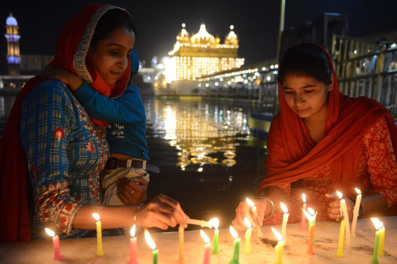 Indian Sikh devotees light candles as they pay their respects as lights glow on the eve of "Bandi Chhor Divas", or "Diwali" festival, at the Golden Temple, in Amritsar. Sikhs celebrate "Bandi Chhor Divas", or "Diwali", to mark the return of the sixth Guru, Guru Hargobind Ji, who was freed from imprisonment and also managed to release 52 political prisoners at the same time from Gwalior fort by Mughal Emperor Jahangir in 1619.  AFP