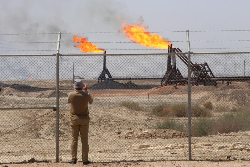 A journalist takes pictures of the West Qurna-1 oilfield, which is operated by ExxonMobil, near Basra, Iraq. Reuters