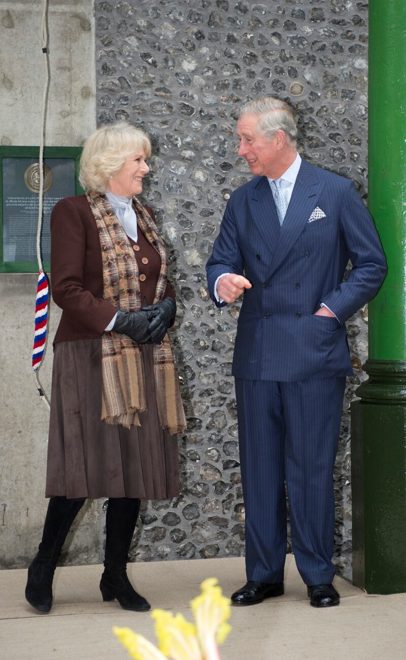 The queen consort, in a brown dress, cardigan and scarf, during a visit to Borough Market in London on February 13, 2013. Getty Images