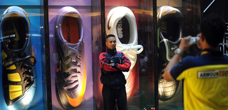 A Malaysian student poses next to the models of Nike sports shoes. Saeed Khan / AFP
